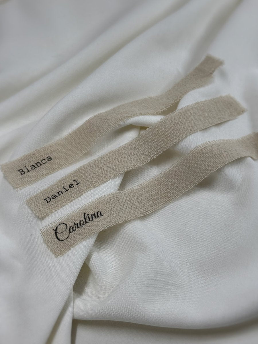 Muestrario de marcasitios de lino natural deshilachados a mano con nombres grabados.